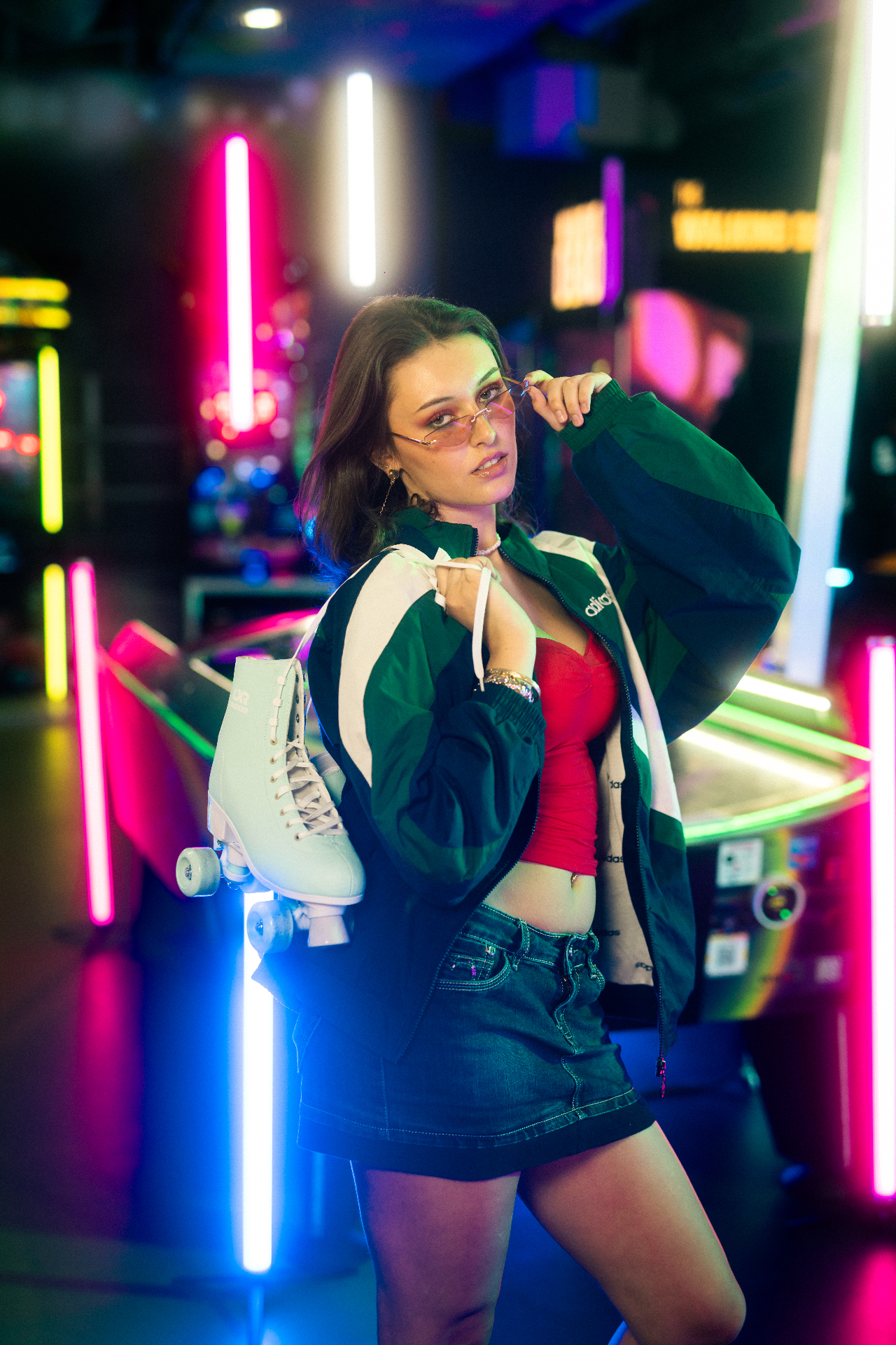 Junge Frau mit Rollschuhen im neonbeleuchteten Arcade-Bereich