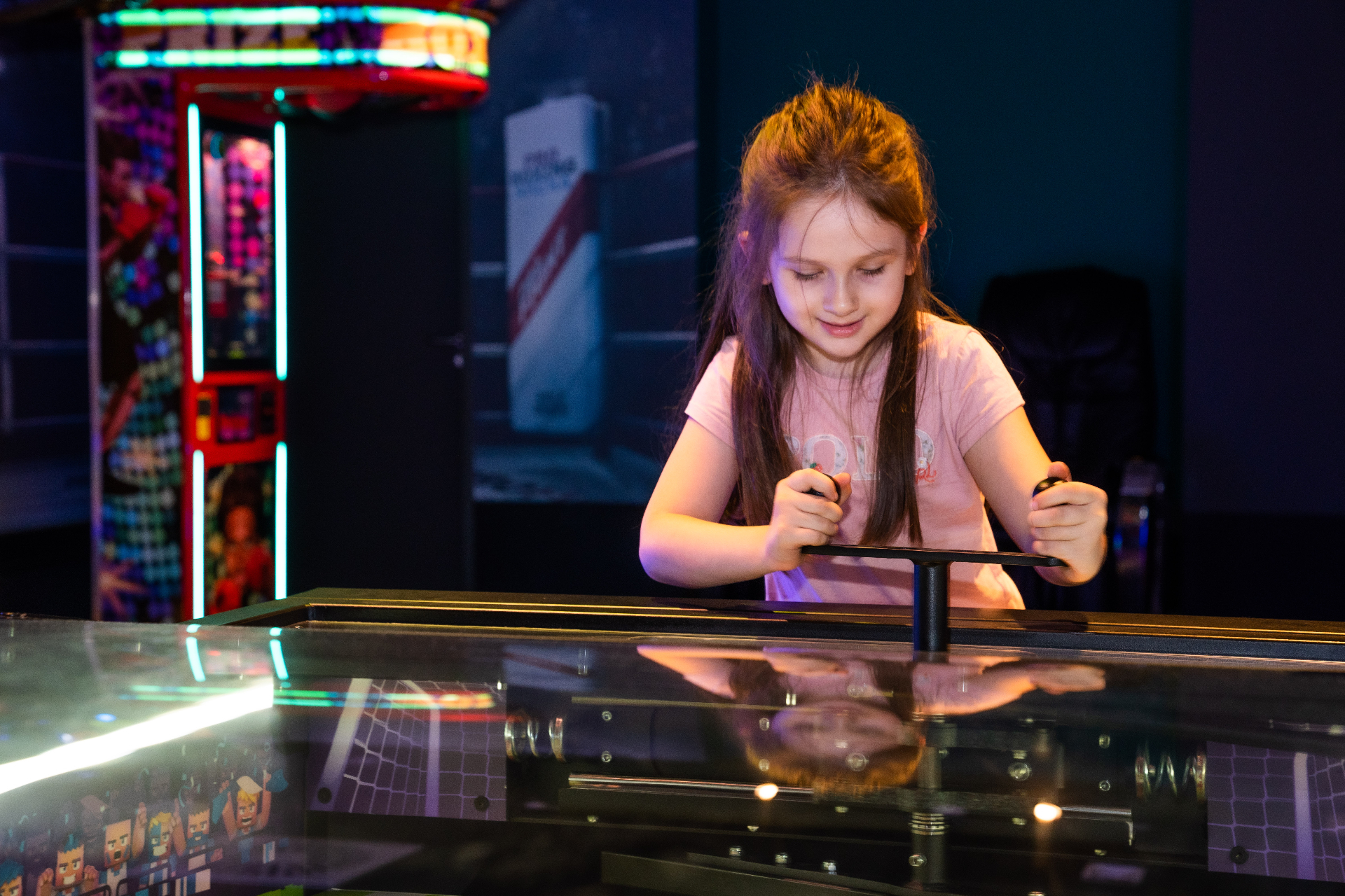 Mädchen konzentriert am Air-Hockey-Tisch in der ActionZone